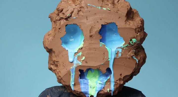 Clay face with paint coming out of eyes and mouth, art by William Cobbing
