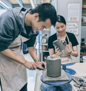 Young people enjoying making mugs in a pottery class